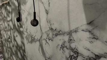 auricolari sospeso liberamente su il bordo di il marmorizzato parete video