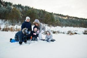 Mother with four children in winter nature. Outdoors in snow. photo