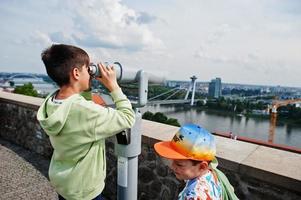Boy looking at touristic telescope of Bratislava view, Slovakia. photo