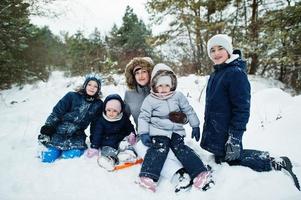 Mother with four children in winter nature. Outdoors in snow. photo