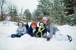 Father and mother with two daughters in winter nature. Outdoors in snow. photo