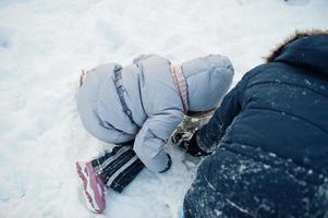 Boy with girl play in winter nature. Outdoors in snow. photo