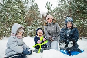 Mother with three children in winter nature. Outdoors in snow. photo