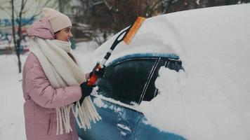 Woman removing snow from car photo