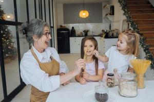 Grandmother and granddaughter are cooking on kitchen. photo