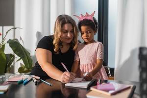 Mother and child daughter draws creatively at the table photo