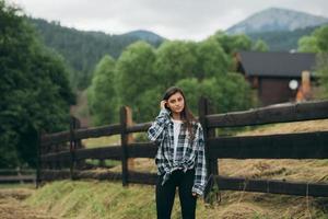 una joven y atractiva mujer caucásica sentada en una cerca foto