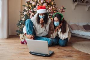 Two girls while speaking with online friend on laptop photo