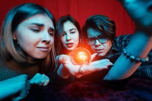 grupo de personas y mujer adivina con bola de cristal foto