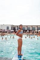 Young woman on the background of the pool in a white swimsuit. photo