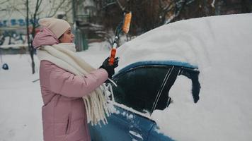 Woman removing snow from car photo