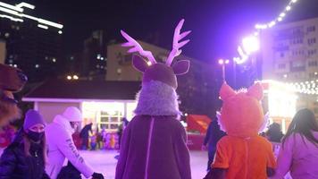 People enjoy ice skating in the street around Christmas tree in rink. photo