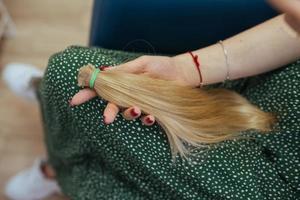 young woman holding her freshly cut long brown hair in pony-tails photo