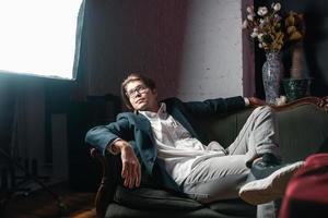 close-up portrait of an attractive young man relaxing on the couch photo