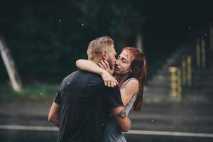 hermosa pareja besándose bajo la lluvia foto