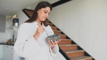 jeune femme en robe utilise un fouet pour mélanger les ingrédients dans un bol video