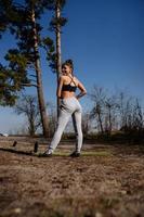 Fitness young woman walks in the park and posing for the camera photo