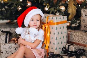 Happy little girl hugs her favorite toy in the room photo