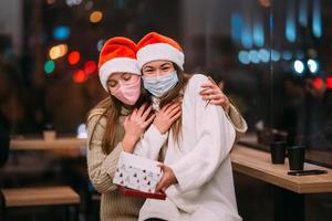 The girl gives a gift to her female friend in caffe photo