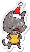 talking cat distressed sticker cartoon of a wearing santa hat vector