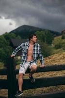 Guy by a fence of pasture enjoying nature. photo