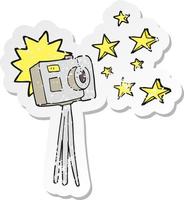 retro distressed sticker of a cartoon camera on tripod with flash vector