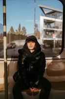 mujer joven sentada en el fondo de una ventana en transporte público foto