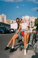 Two young girls in sunglasses posing for the camera on the car parking. photo