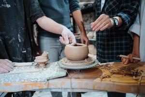 Making a handmade clay pot in the workshop. Pottery lesson with master. photo