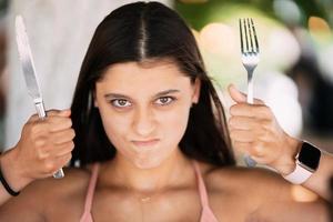 Young beautiful woman holding a knife and a fork photo