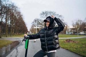 Woman in a jacket on an electric scooter in an autumn park. photo