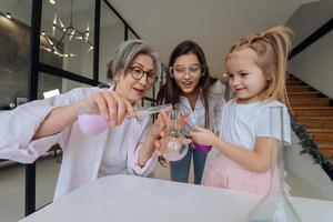 Family doing chemical experiment, mixing flasks indoors