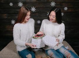 Two young girls holding holiday present photo