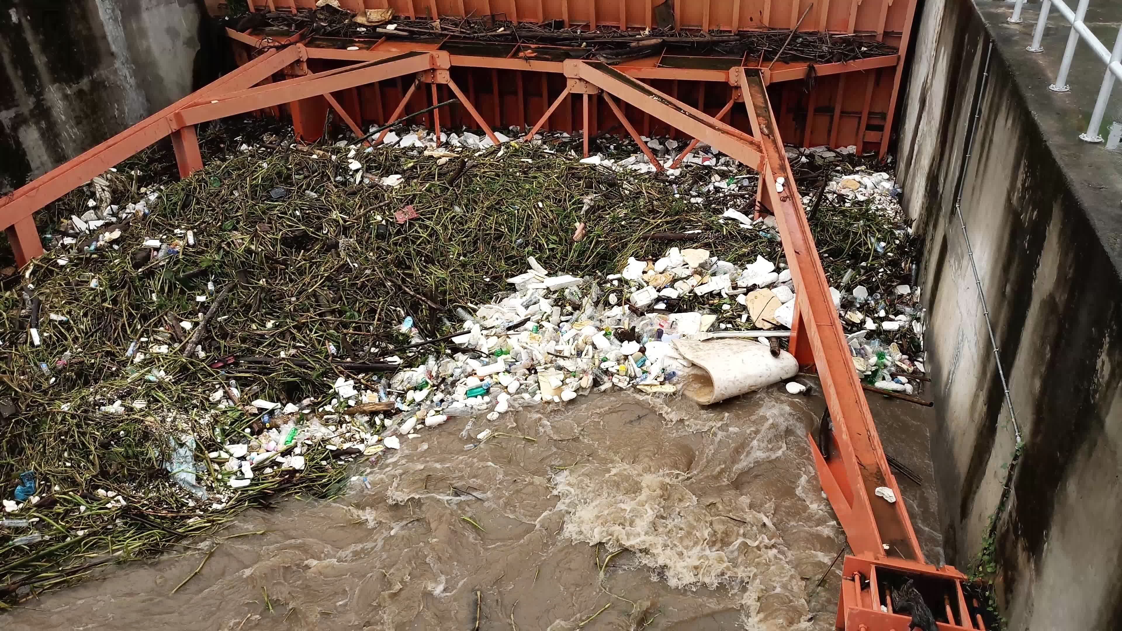 Aerial view of turbid brown forest water released by concrete dam