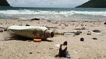 Residuos plásticos usados sucios y ramitas secas en la playa. problema de la basura basura basura derramada en la arena de la playa causada por el hombre. conceptos ambientales y ecológicos. video