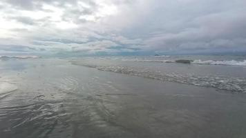 skön hav vågor och vit sand strand i de tropisk ö. mjuk vågor av blå hav på sandig strand bakgrund från topp se från drönare. begrepp av avslappning och resa på semester. video