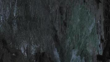 Vertical video, a stream of waterfalls flowing through the rocks. The water is clear blue-green, during the evening time of the Emerald Pool. Krabi video