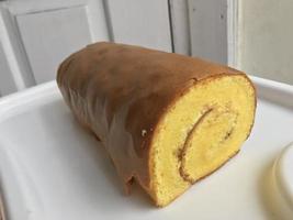 Bolu Gulung or Roll Cake is a type of rolled sponge cake filled with whipped cream, jam or icing. photo