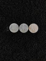 One hundred rupiah Indonesian coin with a picture of a parrot isolated on a dark background photo