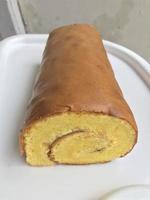 Bolu Gulung or Roll Cake is a type of rolled sponge cake filled with whipped cream, jam or icing. photo