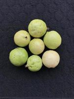 Freshly harvested guava fruit on dark background photo