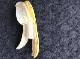 1 banana that has been opened and on a dark background photo