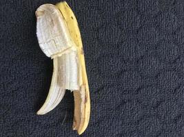 1 banana that has been opened and on a dark background photo