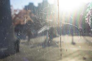 Scratched mirror. Damaged surface of glass. Dirt in display case. Window details. photo