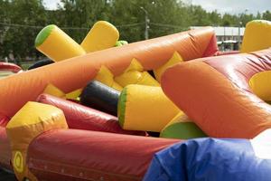 Deflate obstacle course in amusement park. Air escapes from inflatable structure. Details of collection of attractions. photo