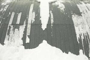 Steel structure in snow. Wall of warehouse after snowstorm. Hedged hangar. photo