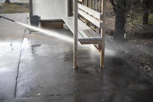 Cleaning on street. Washing bus stop in Russia. High pressure water flow. photo