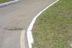 White curb on road. Landscaping in park. photo