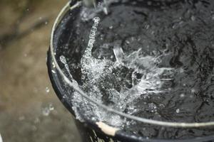 Drops of water. Water in bucket. Rain is falling. photo