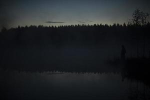 Fog on lake before dawn. Morning fog in forest. photo